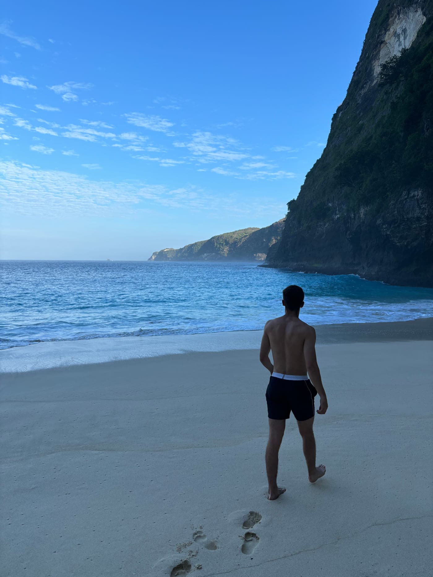 Tom op het strand, met zijn rug naar de camera